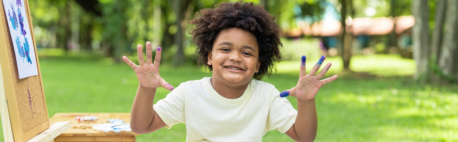 happy-african-american-boy-showing-hands-after-painting-watercolor-white-paper-park