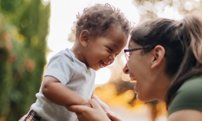 smiling-mother-with-son-playing-outdoors